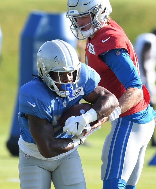 Lions running back Jermar Jefferson takes the handoff from quarterback Tim Boyle during drills.