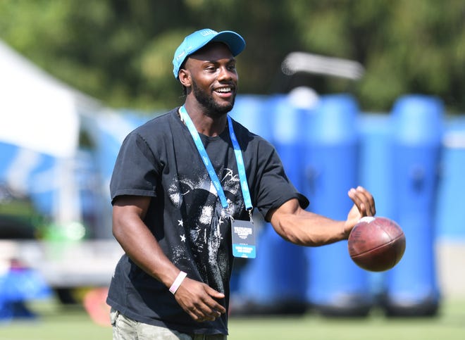 Tigers outfielder Akil Baddoo tosses a football around during a visit to Lions training camp.