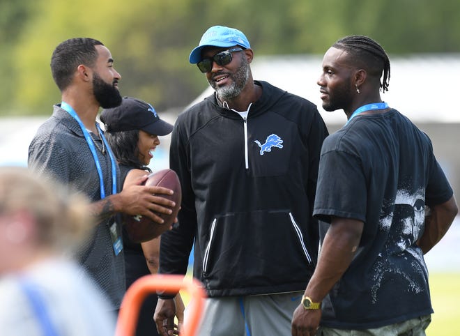 Tigers outfielders Derek Hill, left, and Akil Baddoo talk with Lions general manager Brad Holmes, center, during a visit to Lions training camp.