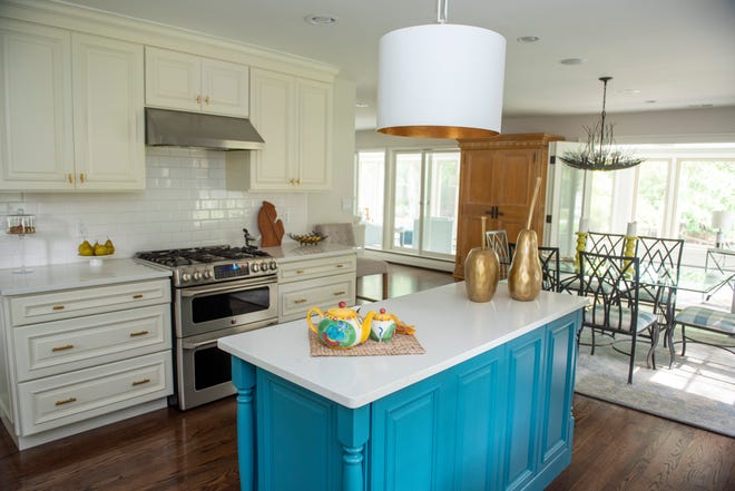 This classic white kitchen got a pop of color with a blue island and some fun accessories like the fruit sculptures displayed on the countertop.