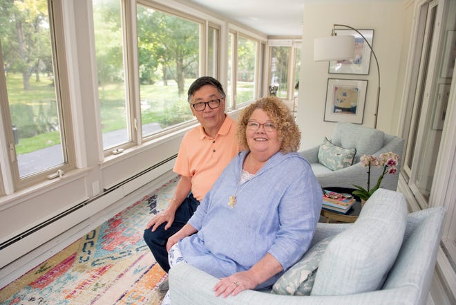 Anne and Bowman Yee sit in the light-filled sunroom of their Farmington Hills home that overlooks a pond on the scenic property.