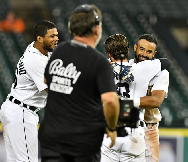 From left, Tigers' Jeimer Candelario and Eric Haase celebrate with Derek Hill after Hill's walk off RBI double to win the game in the eleventh inning.