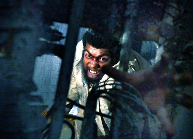 Scare actor Malik Burch comes through the wall during a preview of the Eloise Asylum haunted attraction in Westland on Thursday, Sept. 23, 2021.