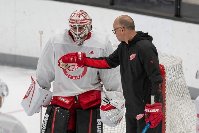 Goaltender Alex Nedeljkovic chats with head coach Jeff Blashill during Red Wings training camp.