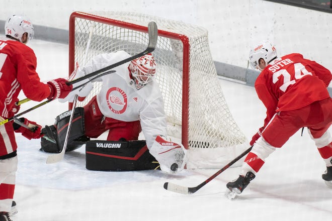 Goaltender Alex Nedeljkovic stops a shot by center Pius Suter during Red Wings training camp.