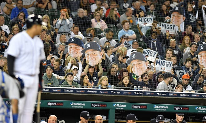 Signs and faces are held up by fans as Tigers designated hitter Miguel Cabrera prepares to bat in the sixth inning of a game last September.