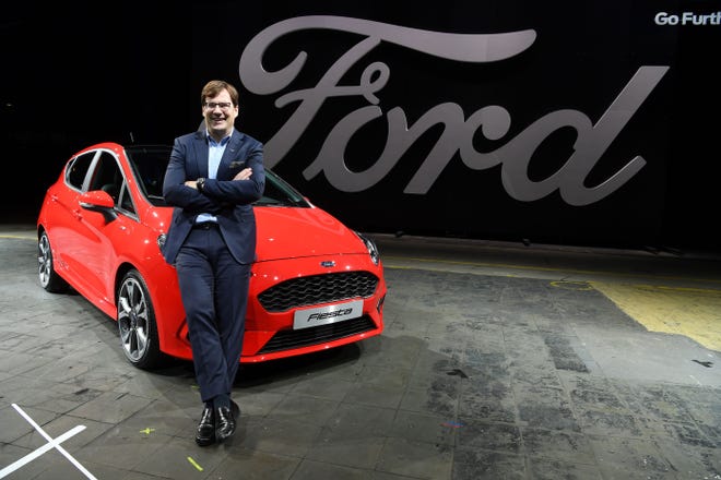 Jim Farley, CEO and chairman of Ford Europe poses in front of a Ford Fiesta model 2017 in Cologne, western Germany, on November 29, 2016.