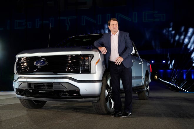 Jim Farley, Ford Motor Company's chief executive officer, stands next to the company's new Ford F-150 Lightning, Wednesday, May 19, 2021, in Dearborn, Mich. On the outside, the electric version of Ford's F-150 pickup looks about the same as the wildly popular gas-powered truck. The new truck called the F-150 Lightning can go up to 300 miles per charge, with a starting price of just under $40,000.