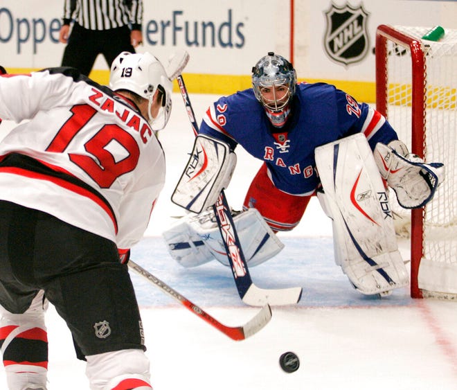 New York Rangers goaltender Al Montoya, right, stops a shot by New Jersey Devils forward Travis Zajac during the first period of their pre-season NHL game in 2007 at Madison Square Garden in N.Y.