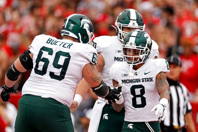 Michigan State wide receiver Jalen Nailor (8) is congratulated by Blake Bueter (69) after scoring a touchdown against Rutgers during the first half of Saturday's college football game in Piscataway, N.J.