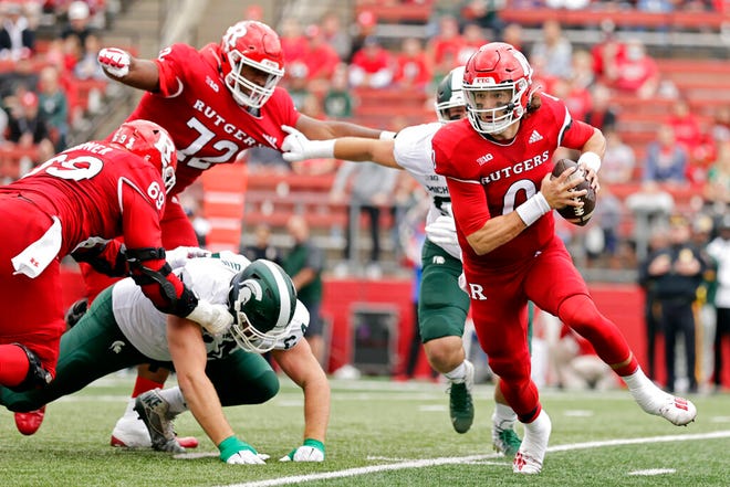 Rutgers quarterback Noah Vedral, right, rushes away from pressure by Michigan State during the first half.