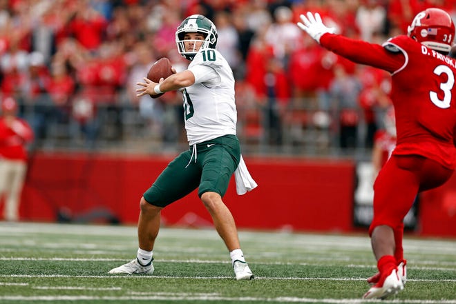 Michigan State quarterback Payton Thorne, left, passes under pressure from Rutgers linebacker Olakunle Fatukasi during the first half.