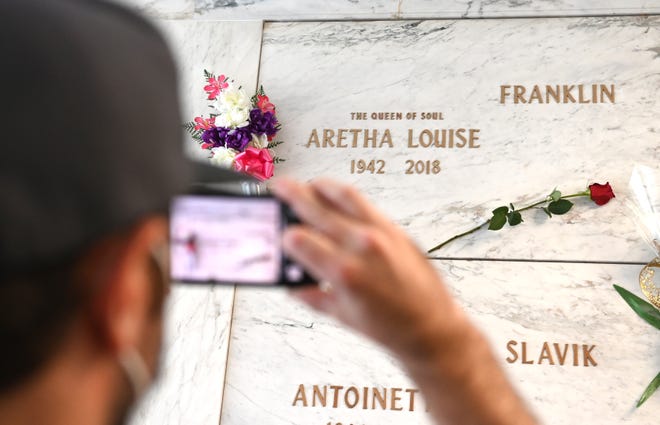 Evan Pougnet of Flint takes a photograph of the Queen of Soul Aretha Franklin's grave stone at the Grand  Mausoleum at Woodlawn Cemetery during a tour given by Preservation Detroit in Detroit on Saturday, October 9, 2021.