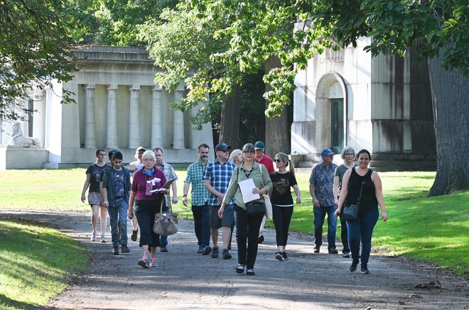 Kathleen Marcaccio, center, a tour guide with Preservation Detroit, walks beyond the Dodge Brothers crypt (at left) during a tour of the Woodlawn Cemetery in Detroit on Saturday, October 9, 2021.