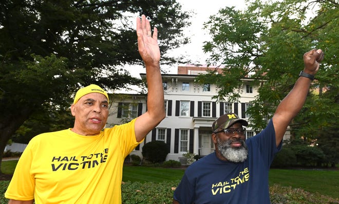 Anderson survivors Chuck Christian, left, and Jon Vaughn wave at a beeping motorist, Wednesday night, October 13, 2021, in front of the UM Presidentâ€™s house. 

XXXX A protest is held in Ann Arbor, Wednesday night, October 13, 2021, at UM with Anderson survivor Jon Vaughn, who is has been camped outside UM President Mark Schlissel's house since Friday. Many Nassar survivors, Anderson survivors and EMU survivors may attend, also. Some are traveling from afar. The idea behind the gathering is to bring solidarity and potential action from UM. Vaughn started protesting in front of Schlissel's house with a demand to meet with the president face to face, along with the Board of Regents. The university has been in mediation for one year with 850 accusers of Anderson, mostly men. (Todd McInturf, The Detroit News)2021.