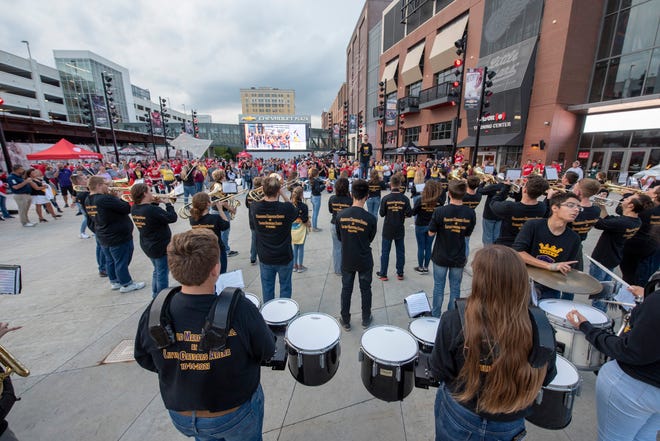 The Blissfield High School marching band plays for fans outside of Little Caesars Arena before the start of the game.