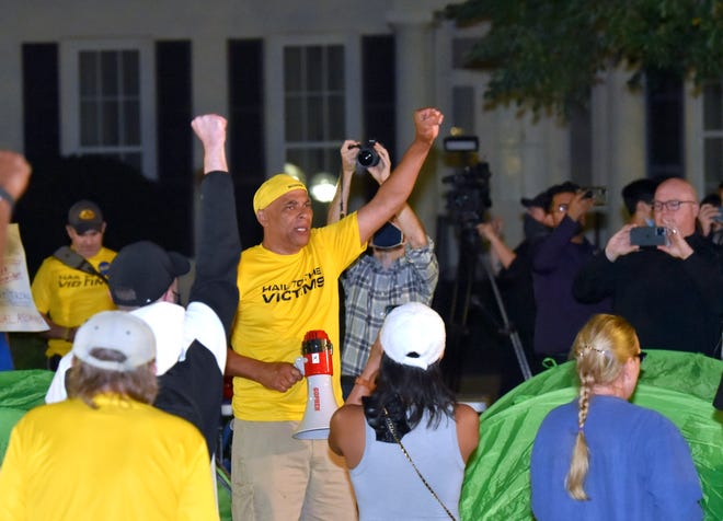 Anderson sexual-assault survivor Chuck Christian, center, fellow survivors and supporters protest in front of the UM President's house, Wednesday night, October 13, 2021.