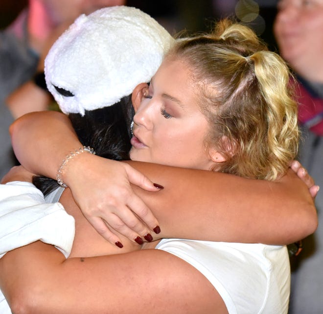 Sexual-assault survivors and friends Jessie Beldelliott, left, of Pontiac, and Rachel Ritchie, of Auburn Hills, become emotional after seeing each other at the protest as they hug, Wednesday night, October 13, 2021.