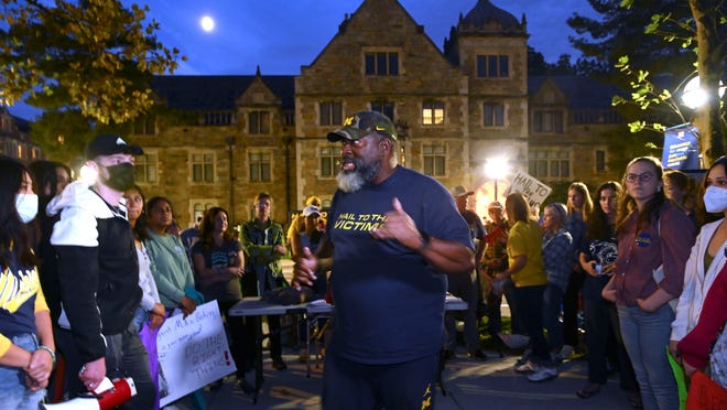 Anderson sexual-assault survivor Jon Vaughn passionately addresses supporters in front of the house of UM President Mark Schlissel's house, Wednesday night, October 13, 2021. In the background is the Lawyer's Club and Munger Residences building.