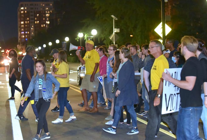Sexual-assault survivors, including, Nassar survivor Kaylee Lorincz, foreground left, walk across S. University Ave. back to the UM President's house, Wednesday night, October 13, 2021.