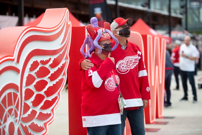 Debbie Nida and her husband Jack, of Monroe, pose for photos outside of Little Caesars Arena before the start of the season  opener between the Detroit Red Wings and Tampa Bay Lightning on Thursday, Oct. 14, 2021, at Little Caesars Arena in Detroit.