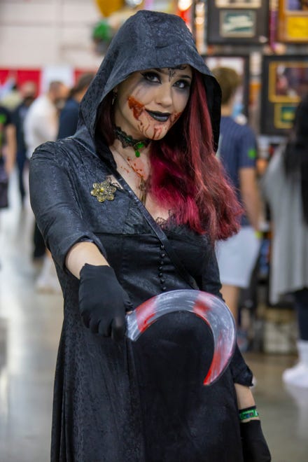 A female Grim Reaper poses for a picture during Motor City Comic Con.