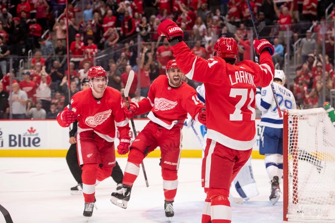 From left, Red Wings right wing Filip Zadina, center Robby Fabbri, and center Dylan Larkin celebrate after Larkin scored the first goal of the season during the first period.