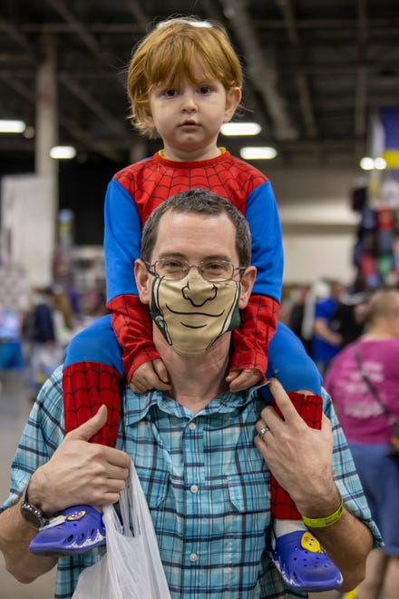 Father, Cort Arnold, holds his son Emmett, dressed as Spiderman, on his shoulders while taking in the sights at Motor City Comic Con event in Novi on Friday, October 15, 2021.
