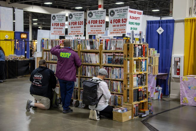 Collectors sort through comic books for sale.