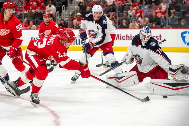 Detroit left wing Lucas Raymond tries to get the puck past Columbus goaltender Joonas Korpisalo during the third period of a game between the Detroit Red Wings and the Columbus Blue Jackets at Little Caesars Arena, in Detroit, October 19, 2021.
