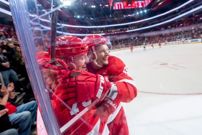 Detroit left wing Adam Erne, left, and center Vladislav Namestnikov celebrate an empty net goal by Erne in the final moments of the third period of a game between the Detroit Red Wings and the Columbus Blue Jackets at Little Caesars Arena, in Detroit, October 19, 2021.