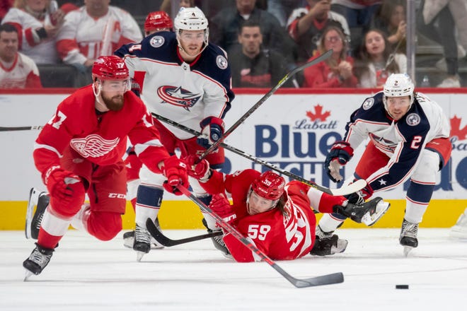 Detroit’s Filip Hronek, left, and Tyler Bertuzzi try to reach the puck before Columbus’ Scott Harrington, left, and Andrew Peeke during the second period.