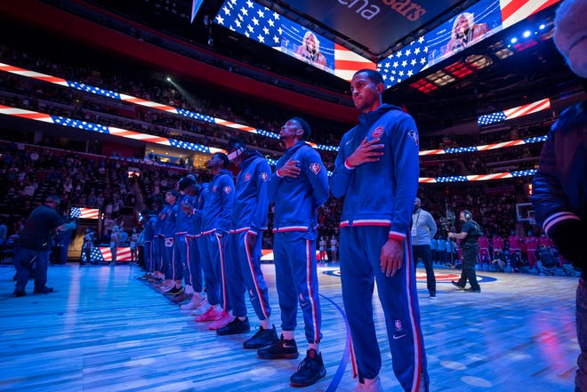 The Pistons stand for the national anthem before the start of the Detroit Pistons’ season home opener against the Chicago Bulls, at Little Caesars Arena, in Detroit, October 20, 2021.
