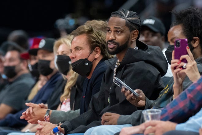 Detroit Pistons team owner Tom Gores, left, and rapper Big Sean enjoy the game from courtside during the second quarter.