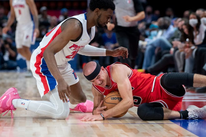 Detroit guard Josh Jackson and Chicago guard Alex Caruso battle for a loose ball during the second quarter.