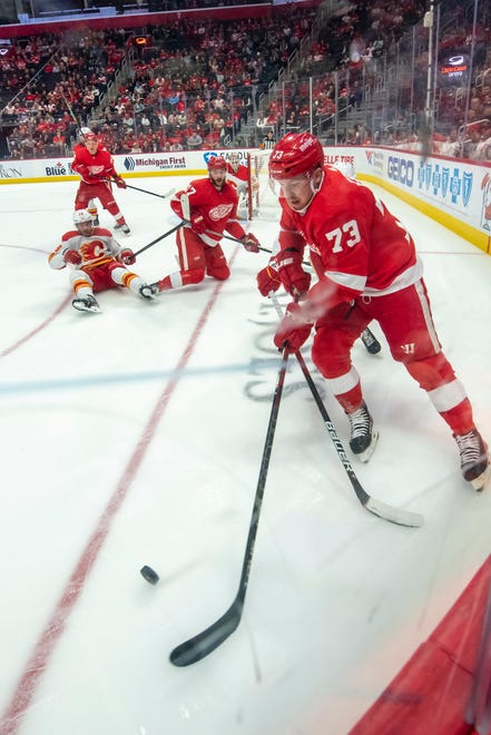 Detroit left wing Adam Erne scoops up the puck during the first period of a game between the Detroit Red Wings and the Calgary Flames, at Little Caesars Arena, in Detroit, October 21, 2021.