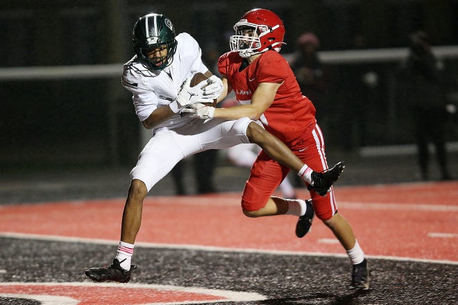 Detroit Cass Tech’s Jemeel Gardner Jr. (9) catches a touchdown pass against Orchard Lake St. Mary’s Brennan Bochenek (5) during their high school football game on Thursday, October 21, 2021 at Orchard Lake St. Mary's High School in West Bloomfield Township.
