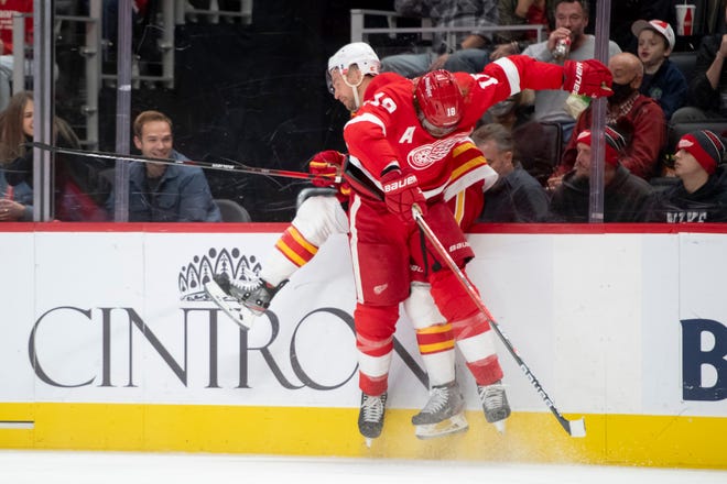 Detroit defenseman Marc Staal checks Calgary center Trevor Lewis into the boards during the third period of a game between the Detroit Red Wings and the Calgary Flames, at Little Caesars Arena, in Detroit, October 21, 2021.