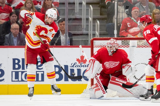 Calgary center Sean Monahan tries to get the puck past Detroit goaltender Alex Nedeljkovic during the third period of a game between the Detroit Red Wings and the Calgary Flames, at Little Caesars Arena, in Detroit, October 21, 2021.