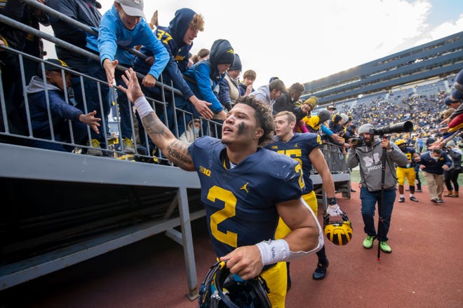 Michigan running back Blake Corum celebrates with the fans after the game.