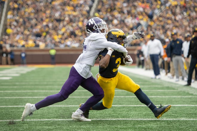Michigan wide receiver A.J. Henning is dragged to the ground by Northwestern defensive back A.J. Hampton Jr. during the second quarter.