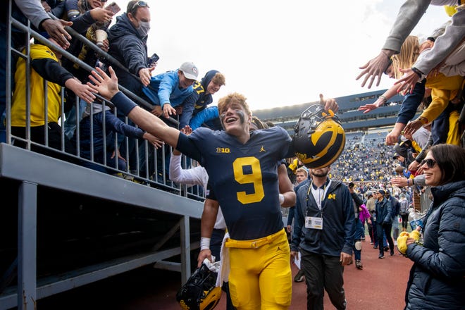 Michigan quarterback J.J. McCarthy celebrates with the fans after the game.