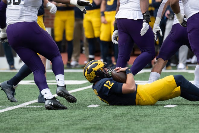 Michigan quarterback Cade McNamara lays on the ground after being sacked during the first quarter.