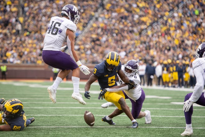 Michigan wide receiver Mike Sainristil fumbles the ball on this play with Northwestern safety Brandon Joseph, left, and defensive back Coco Azema in the final moments of the second quarter.