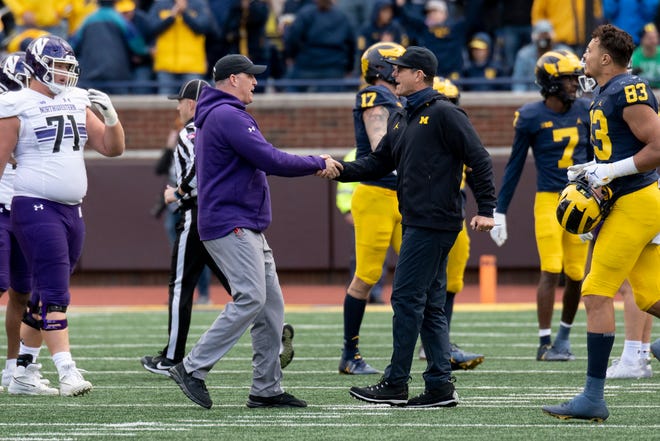 Northwestern coach Pat Fitzgerald, left, and Michigan coach Jim Harbaugh shake hands after the Wolverines defeated the Wildcats, 33-7.