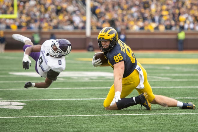 Michigan tight end Luke Schoonmaker shakes off a tackle by Northwestern defensive back Coco Azema during the second quarter.
