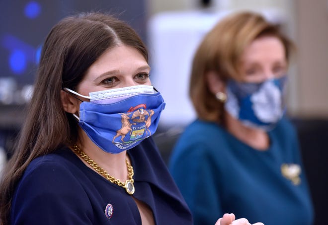 US Congresswoman Haley Stevens, left, wears two masks, including, a mask with the Michigan seal as US House Speaker Nancy Pelosi listens during the roundtable meeting, Saturday afternoon October 23, 2021.