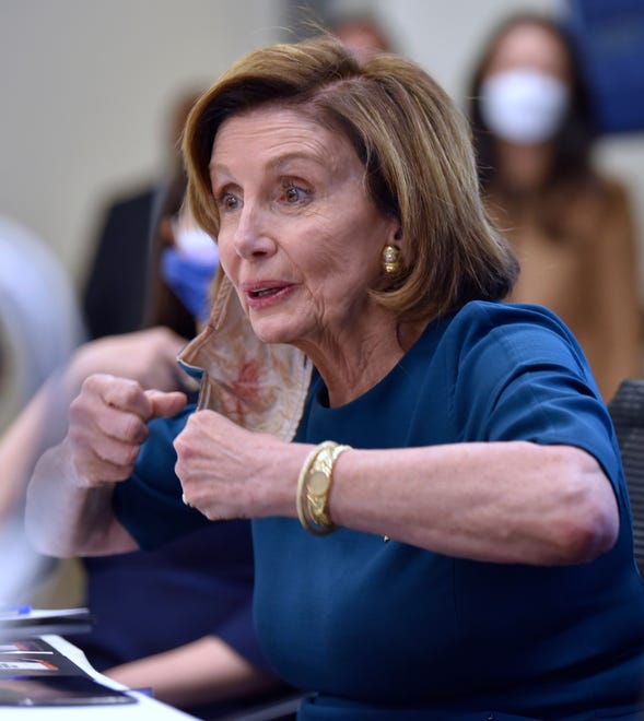 US House Speaker Nancy Pelosi flexes her muscles as she talks during the roundtable meeting, Saturday afternoon October 23, 2021.
