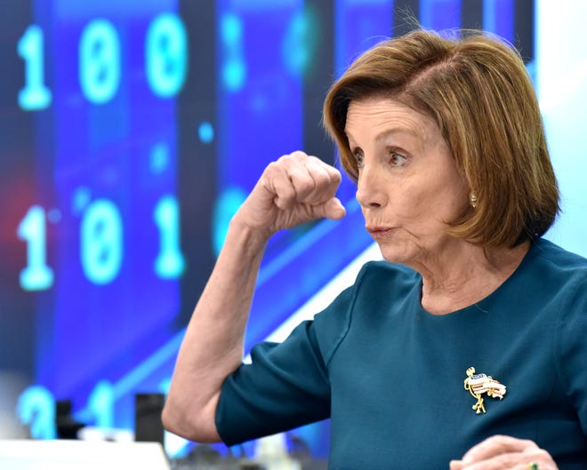 US House Speaker Nancy Pelosi flexes her bicep as she talks about the strength of women in the trades during the roundtable meeting, Saturday afternoon October 23, 2021.