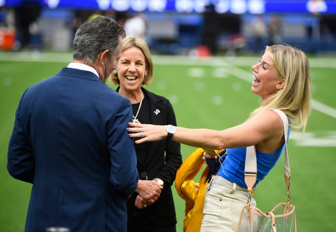 Sheila Ford Hamp, Lions principal owner and chair, and her husband Steve Hamp joke around with Rams quarterback Matthew Stafford's wife Kelly Stafford on the sidelines before the game.